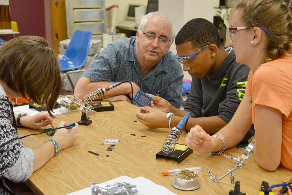 High school students from Project Smart work with an adult mentor on an electronics project