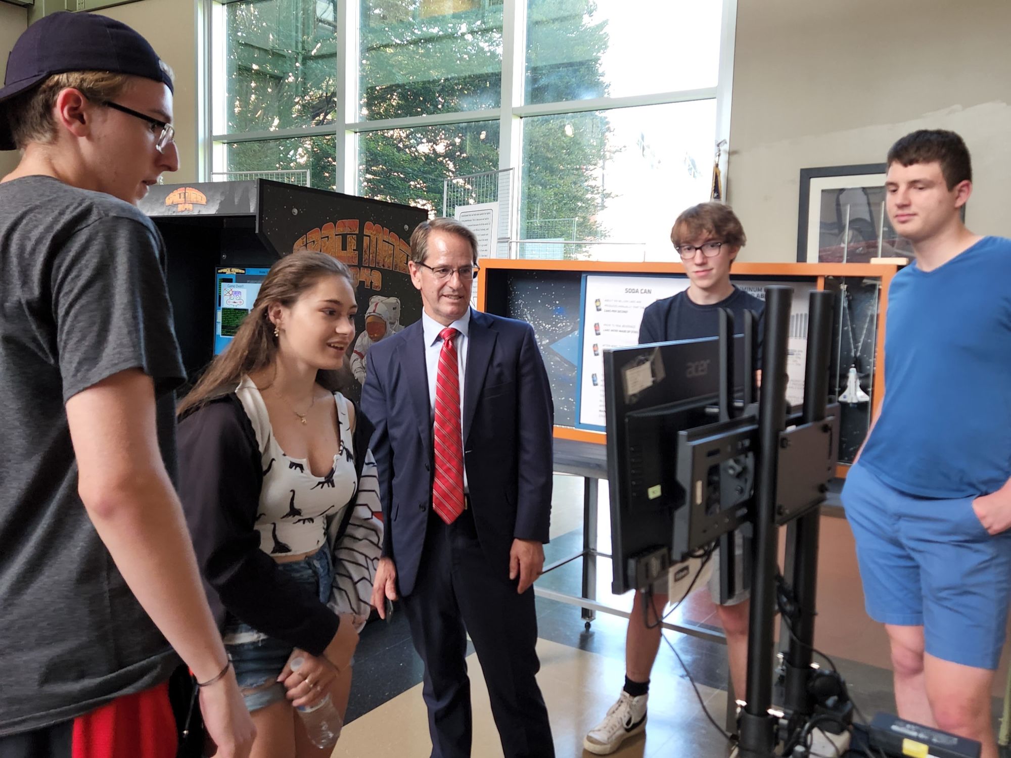 MSDC/SST students Christian Hanson, Olivia Wheeler, David Busnel, and Grant Sorber discuss programming the Power Sources in Space exhibit with Frank Edelblut