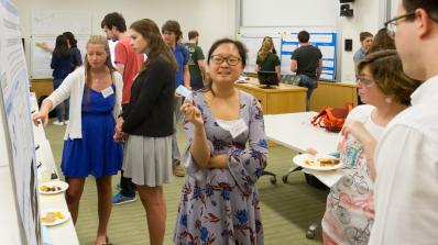 A WISP participant explains her research poster to visitors