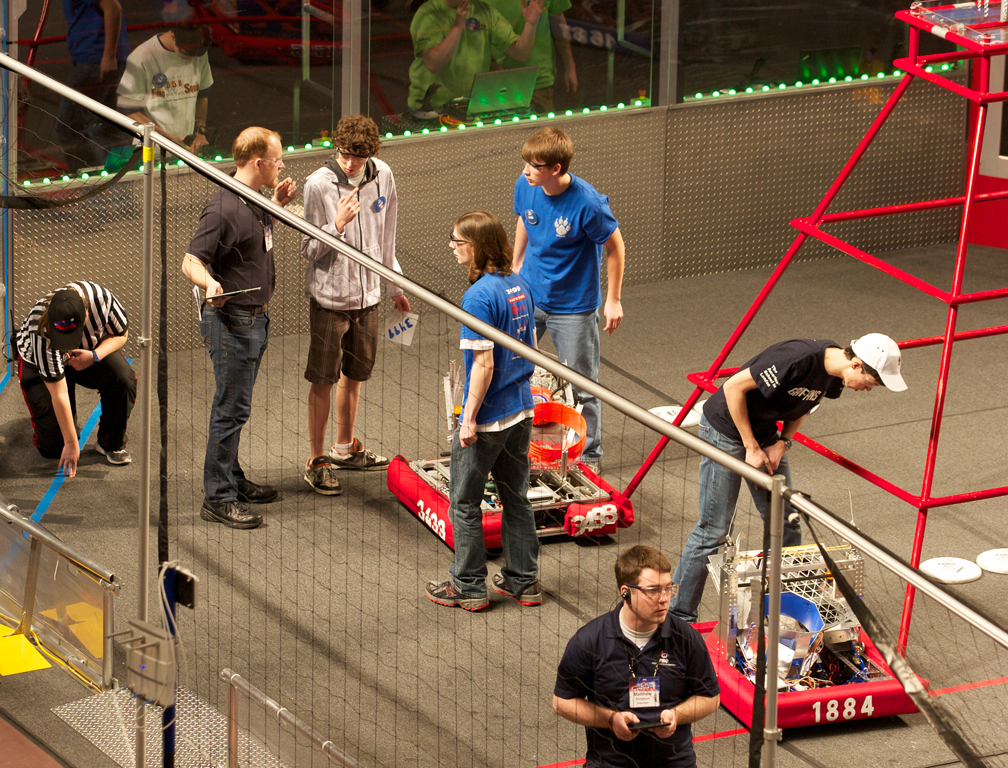 High school students discuss their plans over their robot at a FIRST Robotics meet